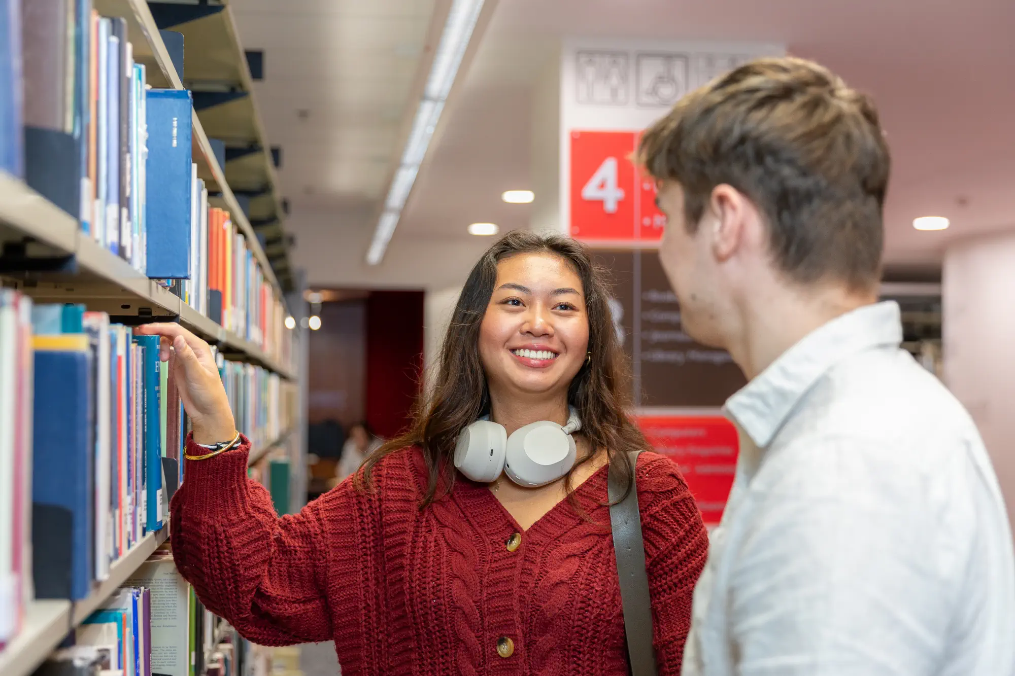 students-standing-at-library-shelf